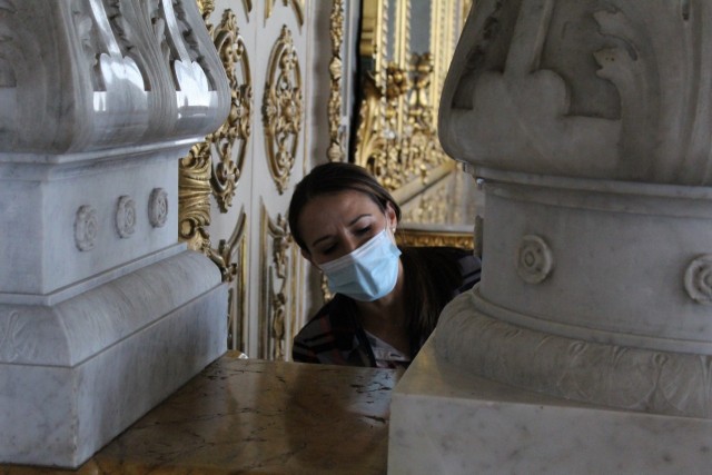 Una investigadora del TEC observa de cerca una pieza de mármol del Teatro Nacional.