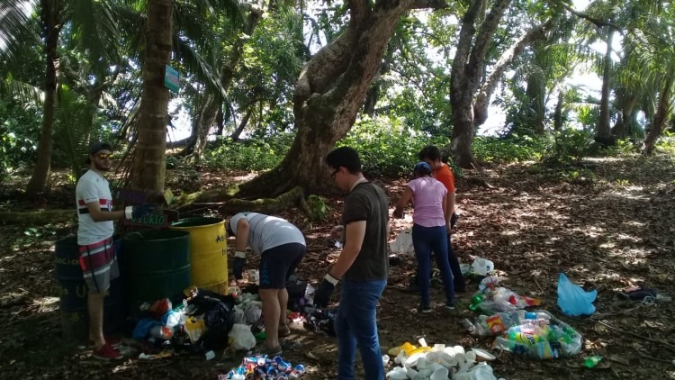 jóvenes recogiendo basura en una isla 