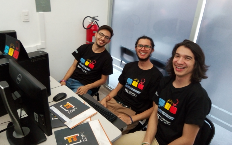 jovenes_programadores_sonriendo_sentados_frente_a_computadora_durante_competencia_