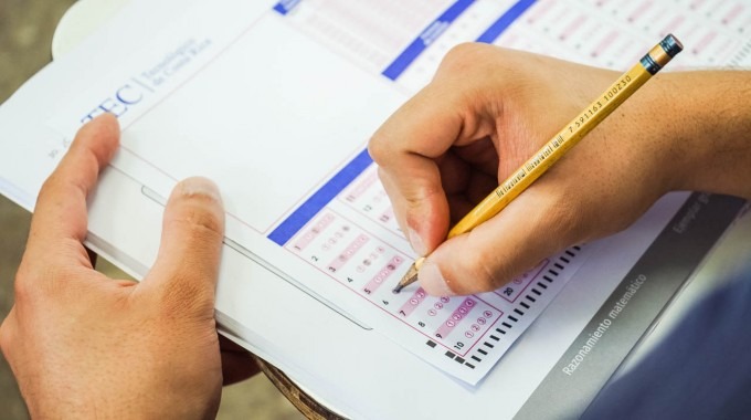 mano con lápiz completando examen de admisión