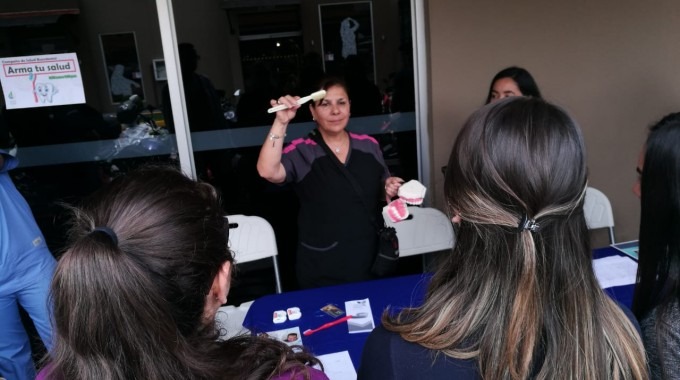 Imagen de una mujer mostrando a los estudiantes de la Sede Interuniversitaria de Alajuela, como se deben de lavar los dientes correctamente.