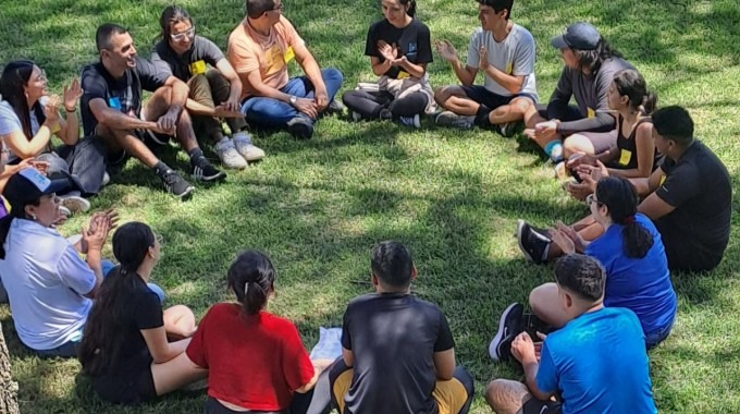 Imagen de varias personas sentadas recibiendo una charla de integración.