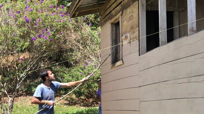 Imagen de un estudiante realizando arreglos a una escuela en Talamanca.