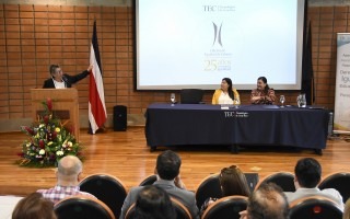 Ana Rosa expone en el podio ante la mirada de la mesa principal.