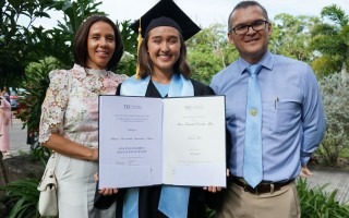 la joven muestra el título junto a sus padres