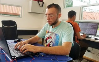 Dos estudiantes en computadoras escribiendo código.