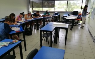 Estudiantes sentados en el aula recibiendo la clase