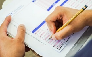 mano con lápiz completando examen de admisión