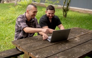 Profesor y estudiante del TEC posan para la fotografía, mientras interactúan en la computadora. 