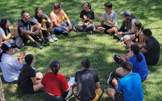 Imagen de varias personas sentadas recibiendo una charla de integración.