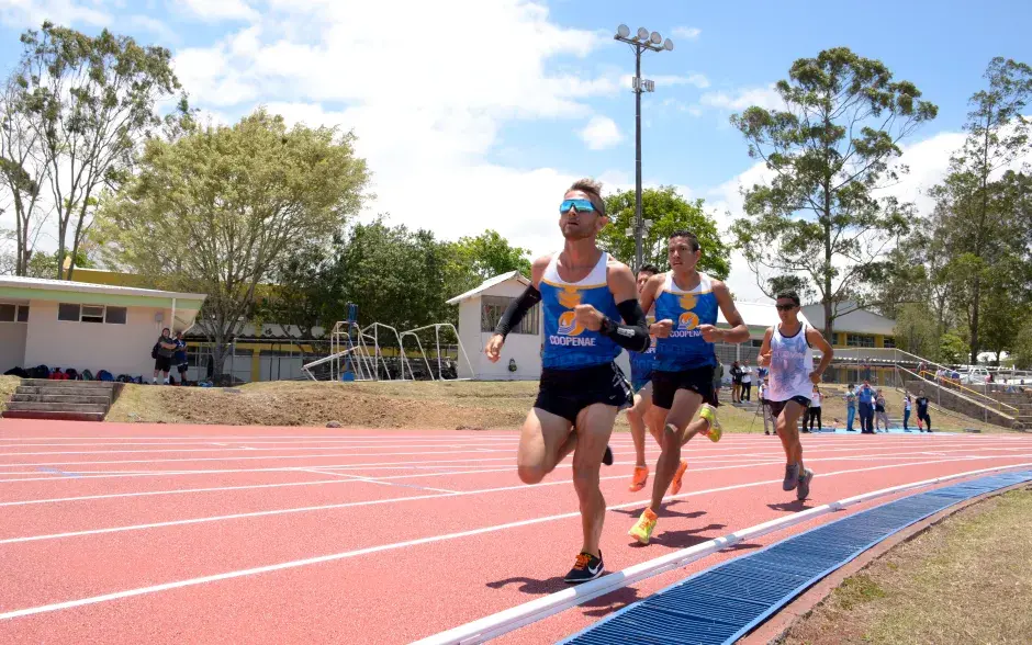 Grupo de personas corriendo en la pista atlética