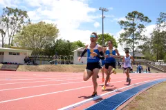 Grupo de personas corriendo en la pista atlética