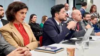 Jerarcas en la mesa con el micrófono.