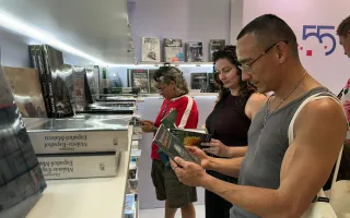 personas visitan el stand del TEC y leen sus libros 