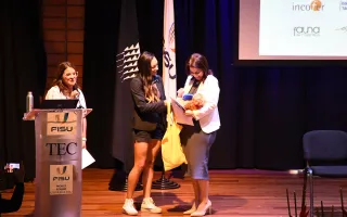 La vicepresidenta Mary Munive recibe un presente por su participación.