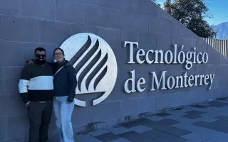 Dos personas posando con el rótulo del Tecnológico de Monterrey
