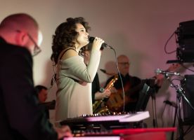 Mujer con un micrófono cantando en un estudio oscuro