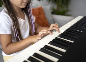 Niña tocando una canción en una organeta