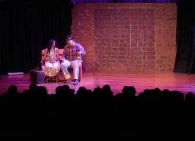 Hombre y mujer actuando en un auditorio